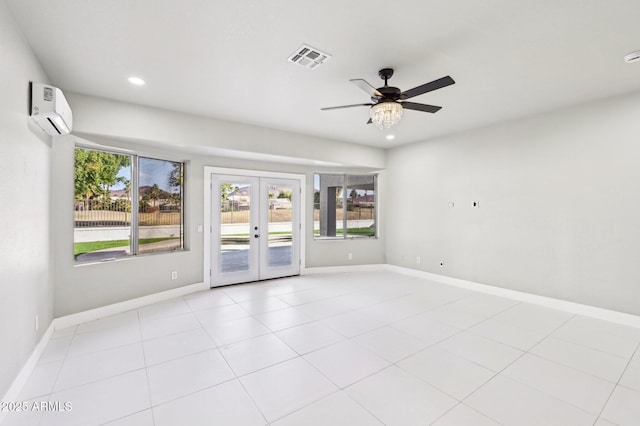 spare room with light tile patterned flooring, an AC wall unit, ceiling fan, and french doors