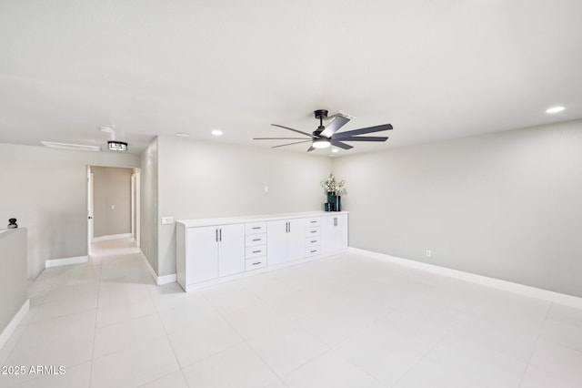 empty room with ceiling fan and light tile patterned floors