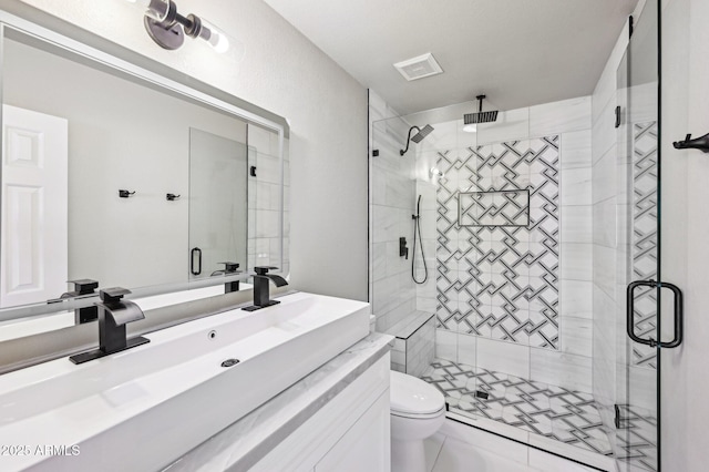 bathroom with toilet, vanity, tile patterned flooring, and walk in shower