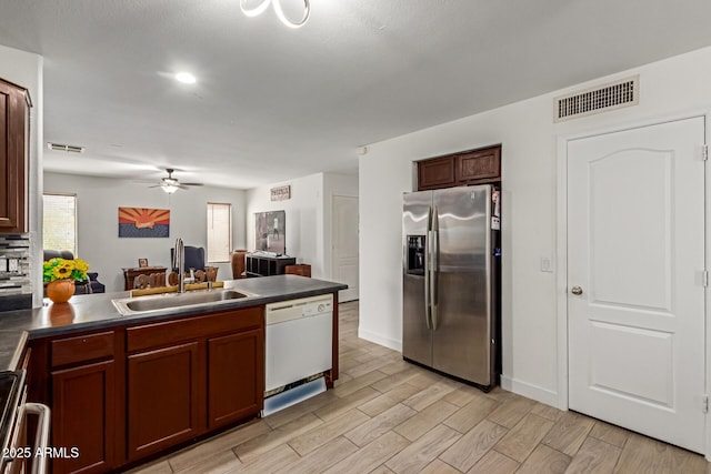 7725 S 47th Ln, Laveen, AZ 85339 - kitchen with appliances with stainless steel finishes, dark countertops, a ceiling fan, a peninsula, and wood finish floors