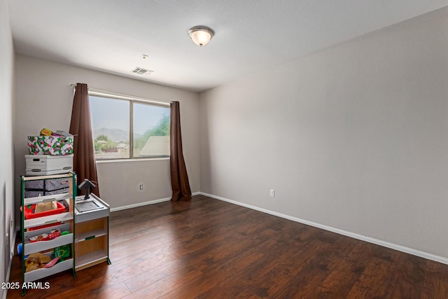 7725 S 47th Ln, Laveen, AZ 85339 - recreation room with baseboards and dark wood-style floors