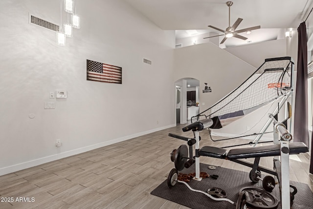 7725 S 47th Ln, Laveen, AZ 85339 - exercise room featuring arched walkways, ceiling fan, light wood-type flooring, and high vaulted ceiling