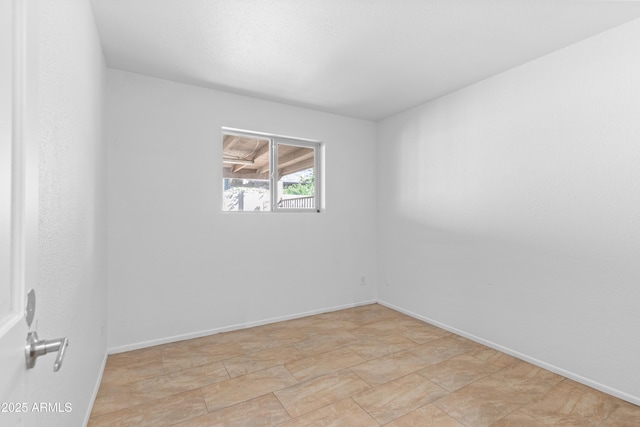 unfurnished room with baseboards