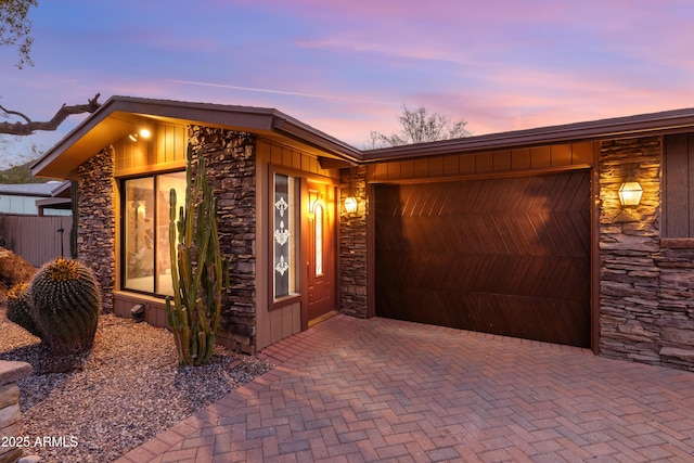 view of front of house featuring stone siding and decorative driveway