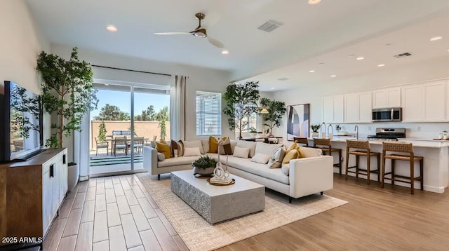 23244 W Tamarisk Ave, Buckeye, AZ 85326 - living room featuring light wood finished floors, recessed lighting, and ceiling fan