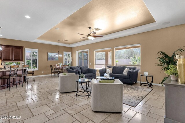5342 S Citrus Ct, Gilbert, AZ 85298 - living room featuring a raised ceiling, baseboards, stone tile flooring, a ceiling fan, and recessed lighting