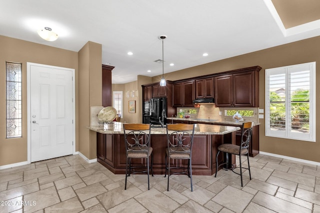 5342 S Citrus Ct, Gilbert, AZ 85298 - kitchen with a peninsula, stone tile floors, black appliances, and baseboards