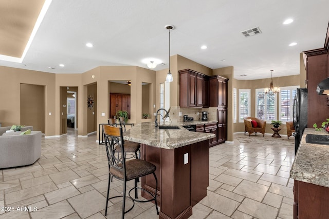 5342 S Citrus Ct, Gilbert, AZ 85298 - kitchen featuring a sink, a peninsula, open floor plan, a breakfast bar area, and backsplash