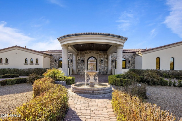 exterior space with stone siding and a tiled roof