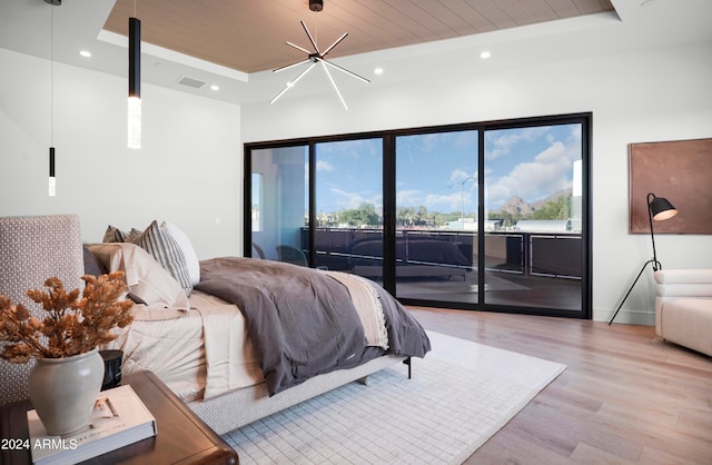 bedroom with light wood-type flooring, access to outside, wood ceiling, and a raised ceiling