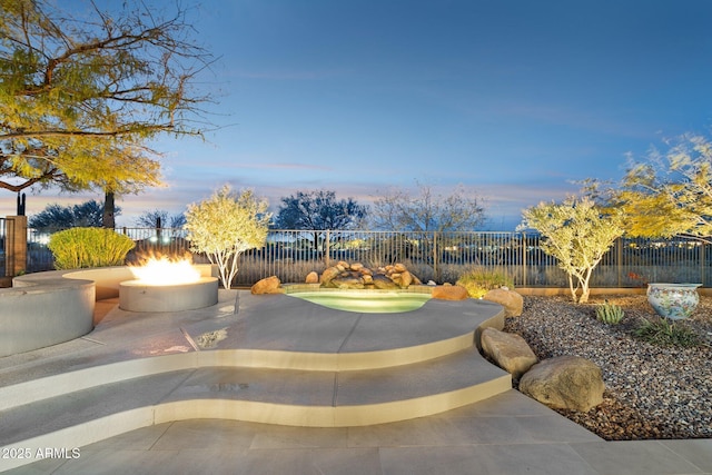 view of patio featuring fence and a fire pit