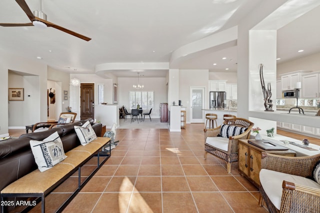 living room with ceiling fan with notable chandelier and light tile patterned flooring