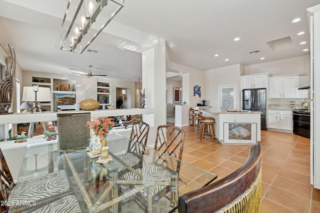 tiled dining space with sink, ceiling fan, and built in shelves