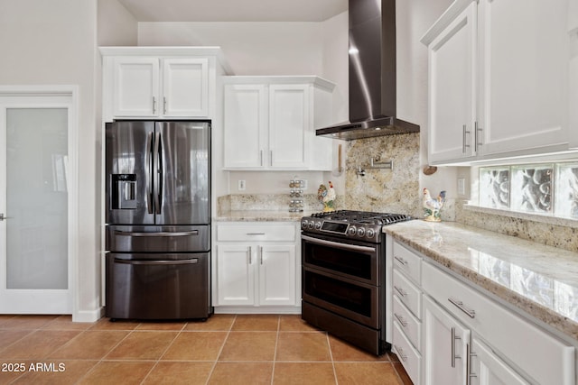 kitchen featuring stainless steel appliances, light tile patterned flooring, white cabinets, and wall chimney exhaust hood