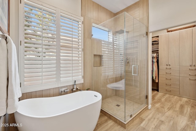 bathroom with plus walk in shower, plenty of natural light, and hardwood / wood-style floors