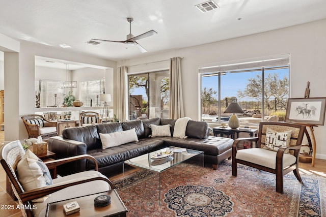 living room featuring ceiling fan, visible vents, and a healthy amount of sunlight