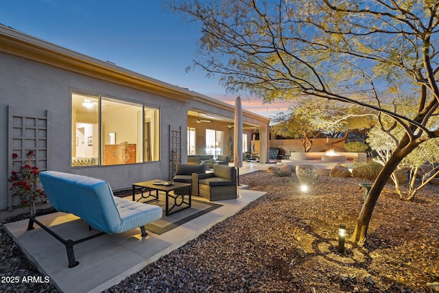 patio terrace at dusk featuring an outdoor living space with a fire pit