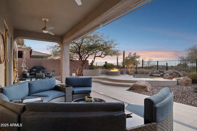 patio terrace at dusk with ceiling fan and an outdoor hangout area