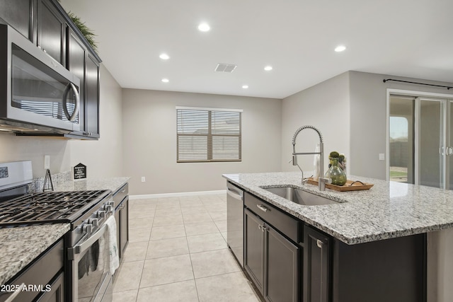 30776 W Earll Dr, Buckeye, AZ 85396 - kitchen with stainless steel appliances, a sink, an island with sink, light stone countertops, and recessed lighting