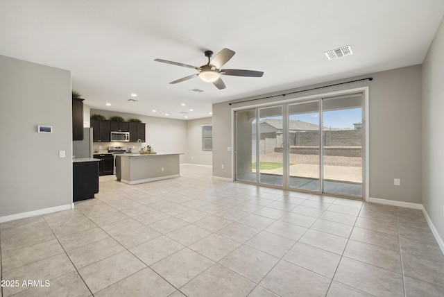 30776 W Earll Dr, Buckeye, AZ 85396 - unfurnished living room with ceiling fan, light tile patterned flooring, recessed lighting, and baseboards