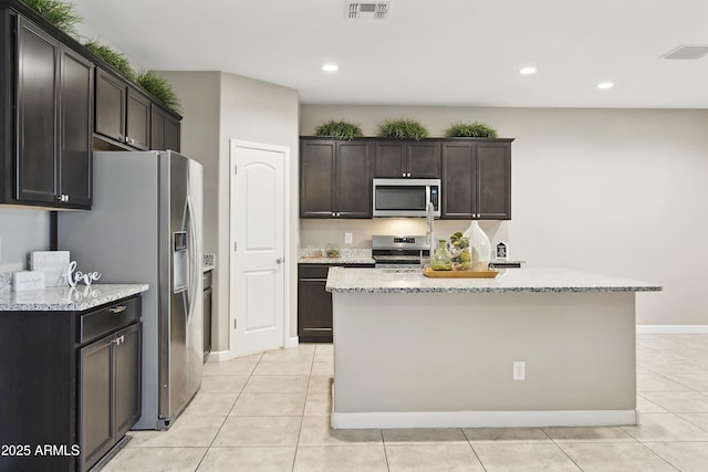 30776 W Earll Dr, Buckeye, AZ 85396 - kitchen featuring appliances with stainless steel finishes, light stone counters, recessed lighting, light tile patterned floors, and a center island