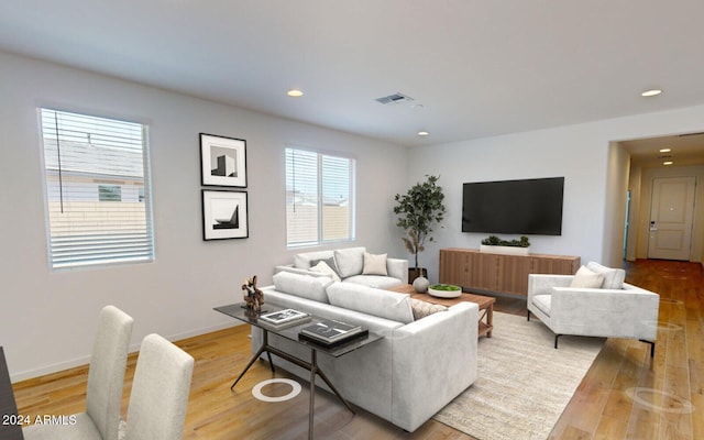 living area featuring recessed lighting, baseboards, light wood finished floors, and visible vents