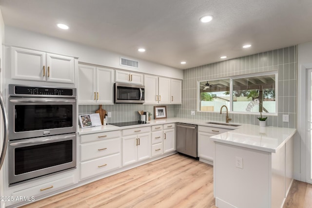 510 N Entrada St, Chandler, AZ 85226 - kitchen featuring appliances with stainless steel finishes, a sink, a peninsula, white cabinetry, and backsplash