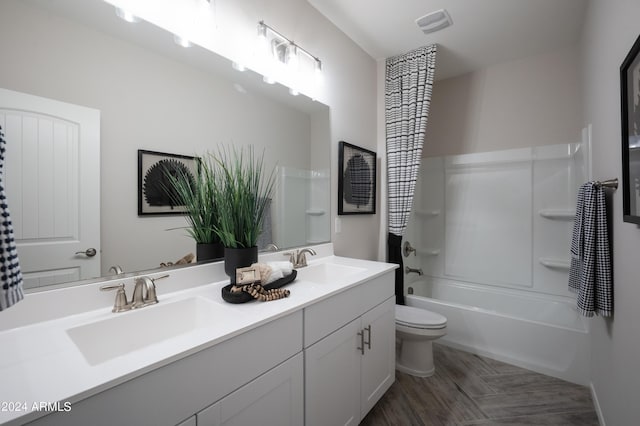 full bath featuring double vanity, shower / washtub combination, toilet, and a sink