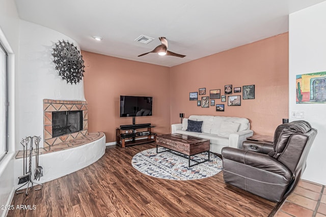 9035 W Villa Chula, Peoria, AZ 85383 - living area with visible vents, wood finished floors, baseboards, ceiling fan, and a fireplace with raised hearth