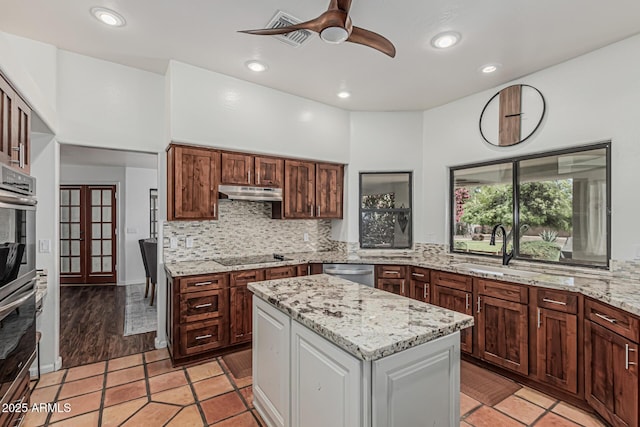 9035 W Villa Chula, Peoria, AZ 85383 - kitchen featuring decorative backsplash, a sink, under cabinet range hood, a ceiling fan, and appliances with stainless steel finishes