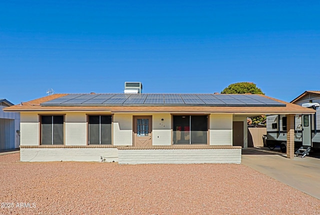 ranch-style home featuring solar panels