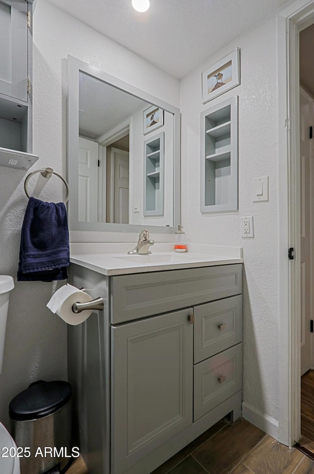 bathroom featuring vanity, hardwood / wood-style flooring, and toilet