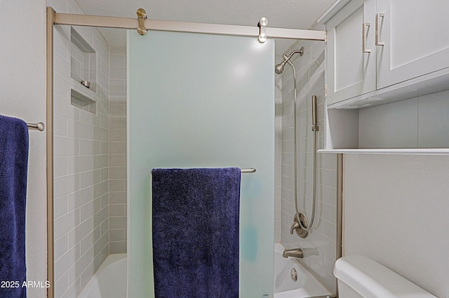 bathroom with tiled shower / bath combo and toilet