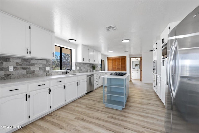 kitchen featuring light wood-type flooring, white cabinets, and appliances with stainless steel finishes