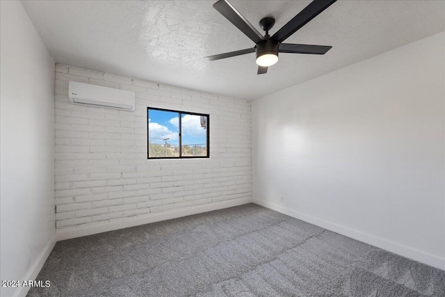 empty room with a textured ceiling, an AC wall unit, ceiling fan, brick wall, and carpet