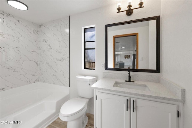 full bathroom featuring vanity, tiled shower / bath, and toilet