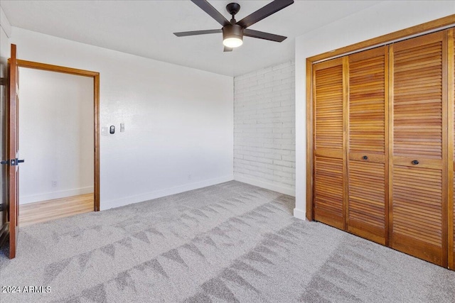 unfurnished bedroom featuring ceiling fan, a closet, and light carpet