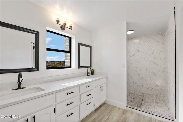 bathroom featuring a tile shower, vanity, and hardwood / wood-style flooring