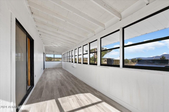 unfurnished sunroom with a mountain view and lofted ceiling with beams