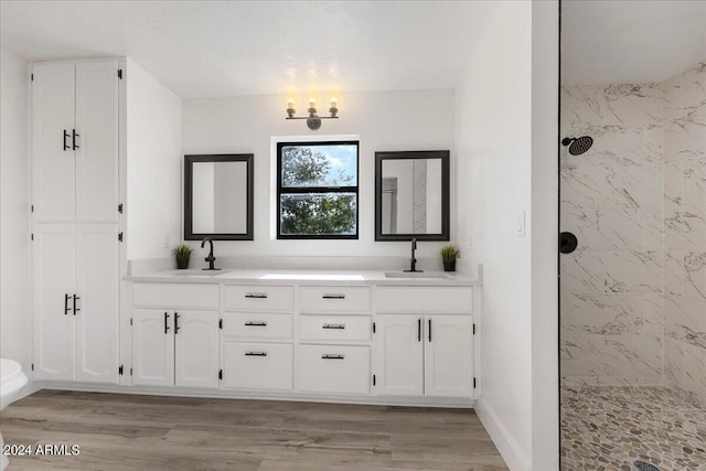 bathroom with vanity, hardwood / wood-style flooring, and tiled shower