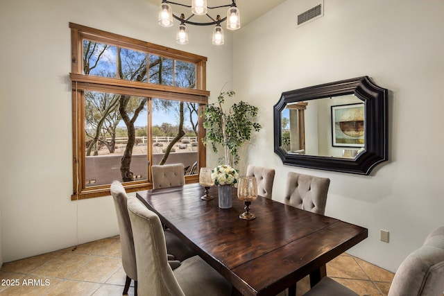 dining area featuring light tile patterned floors, visible vents, and a chandelier