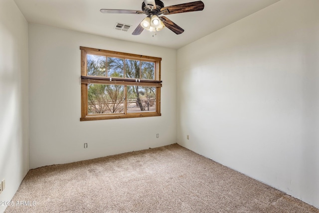 carpeted empty room with a ceiling fan and visible vents