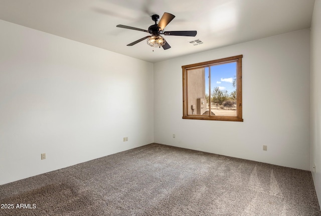 spare room featuring visible vents, ceiling fan, and carpet