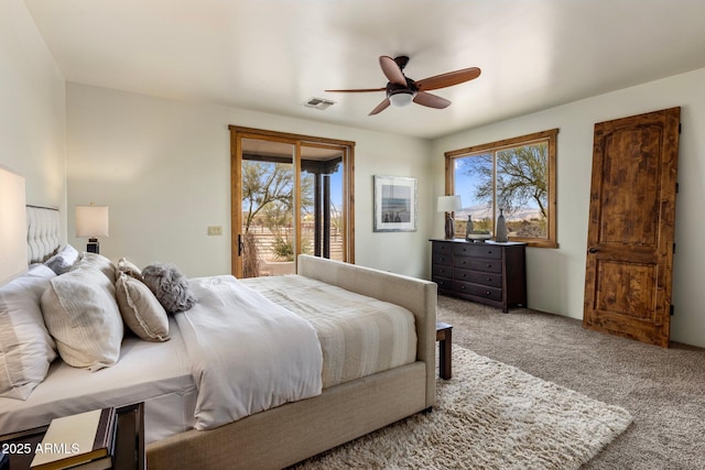 bedroom featuring access to exterior, visible vents, multiple windows, and carpet floors