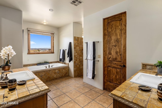 full bathroom with visible vents, a bath, vanity, and tile patterned flooring