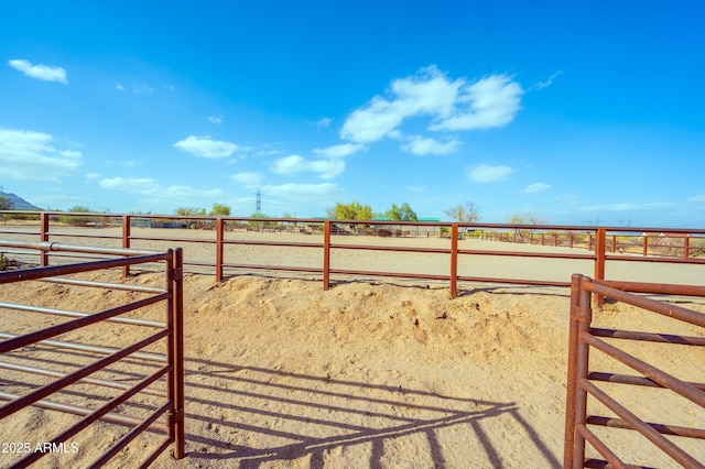 view of gate with an outbuilding, a rural view, and an exterior structure