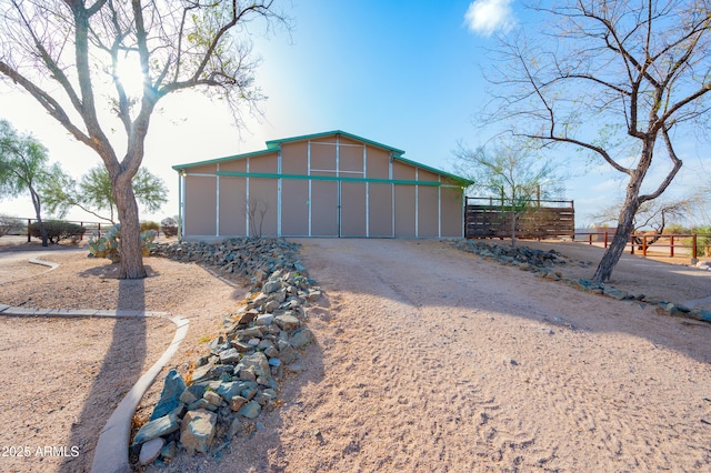 garage with gravel driveway and fence