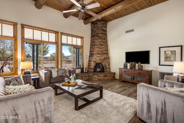 living room with visible vents, wood finished floors, wooden ceiling, a fireplace, and a towering ceiling