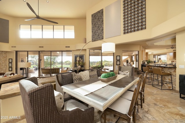 dining area with a high ceiling and ceiling fan