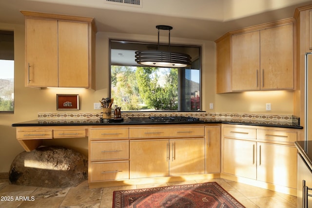 kitchen featuring light brown cabinetry, pendant lighting, and stainless steel gas stovetop